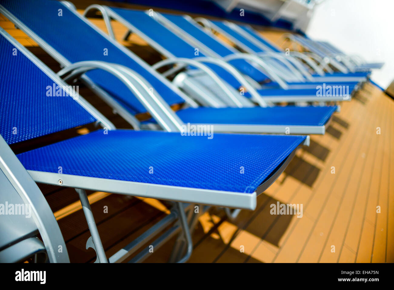 blue sun beds lined up on deck Stock Photo