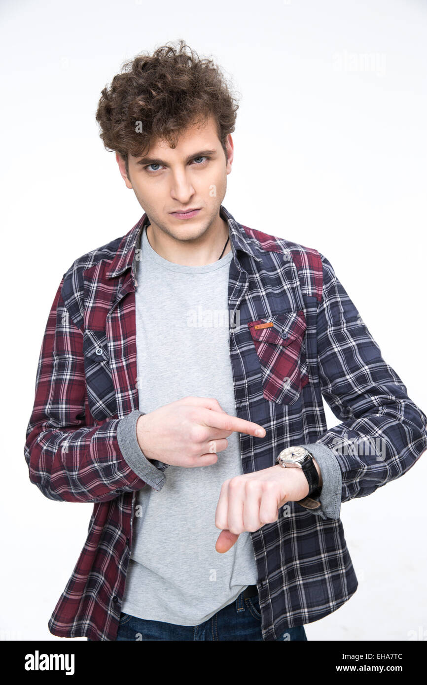 Angry young man pointing on the wristwatch Stock Photo