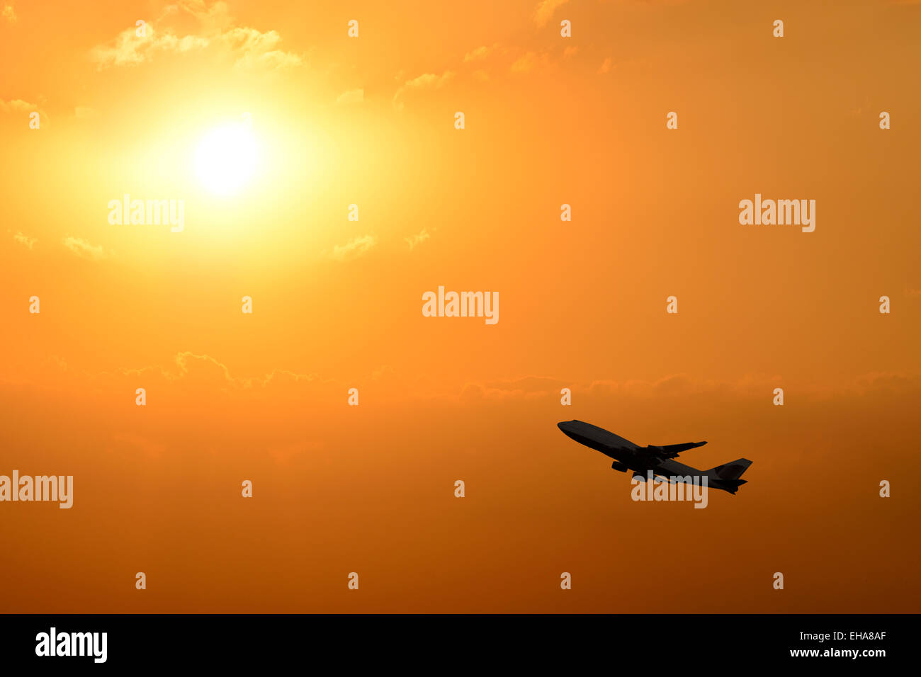 Airplane Taking Off Silhouetted Against a Sunset. Stock Photo