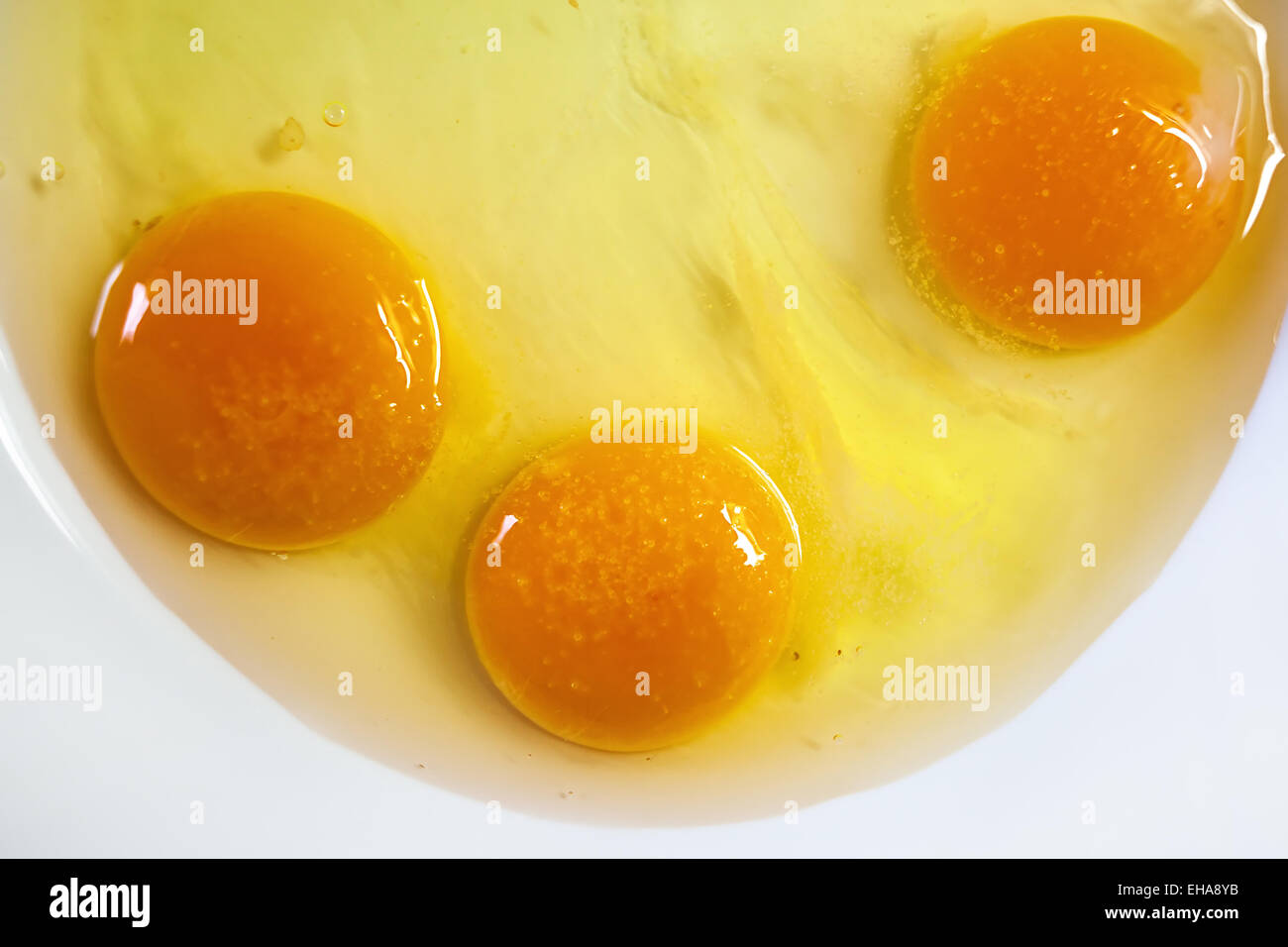 Details of three eggs in plate, ready to be prepared for lunch. Stock Photo
