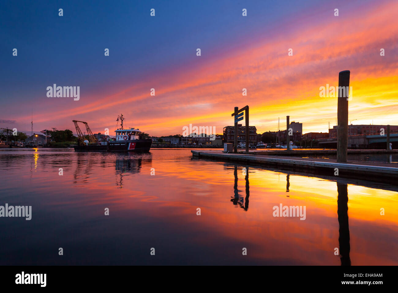 A boat pulling into harbor and coming home at sunset. Stock Photo