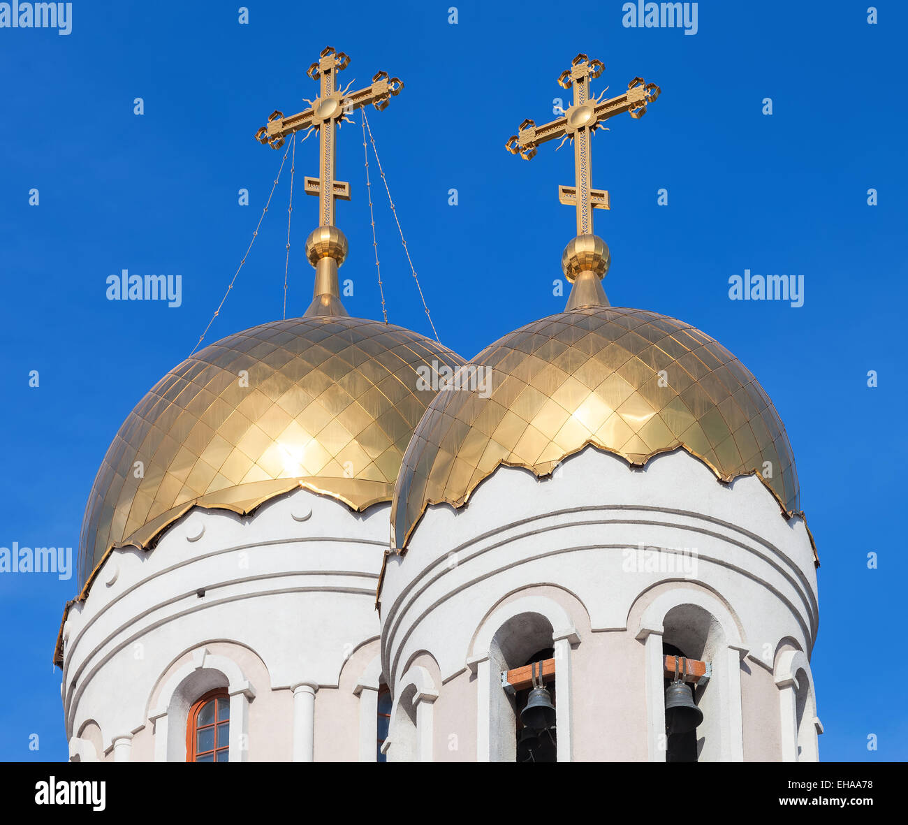 Golden domes of Russian orthodox church with cross against blue sky ...