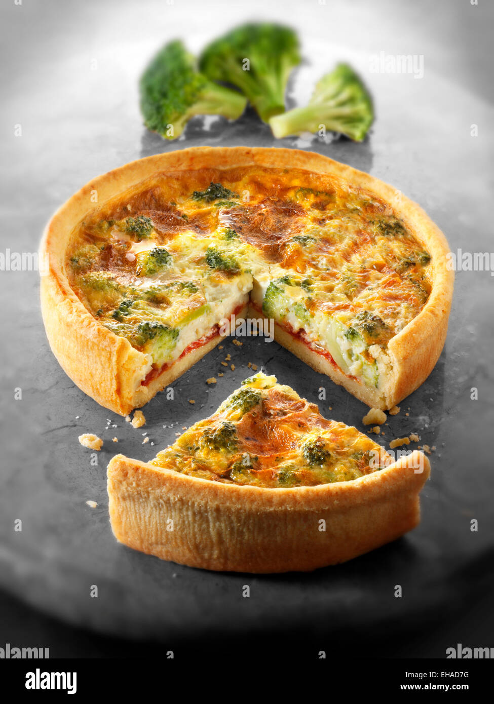 Whole broccoli quiche with a slice out Stock Photo