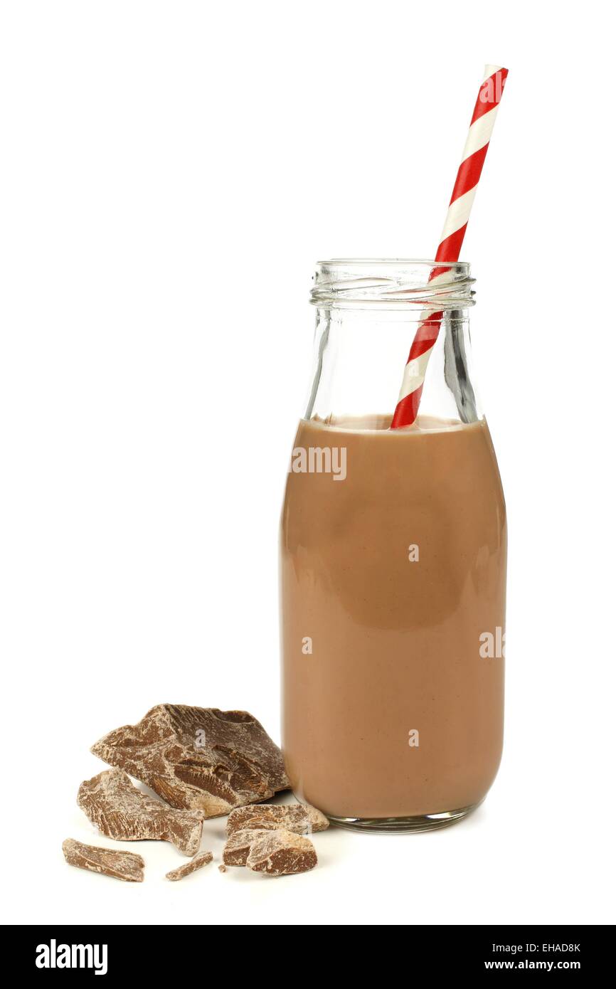 Chocolate milk with straw in traditional bottle with chocolate pieces isolated on white Stock Photo