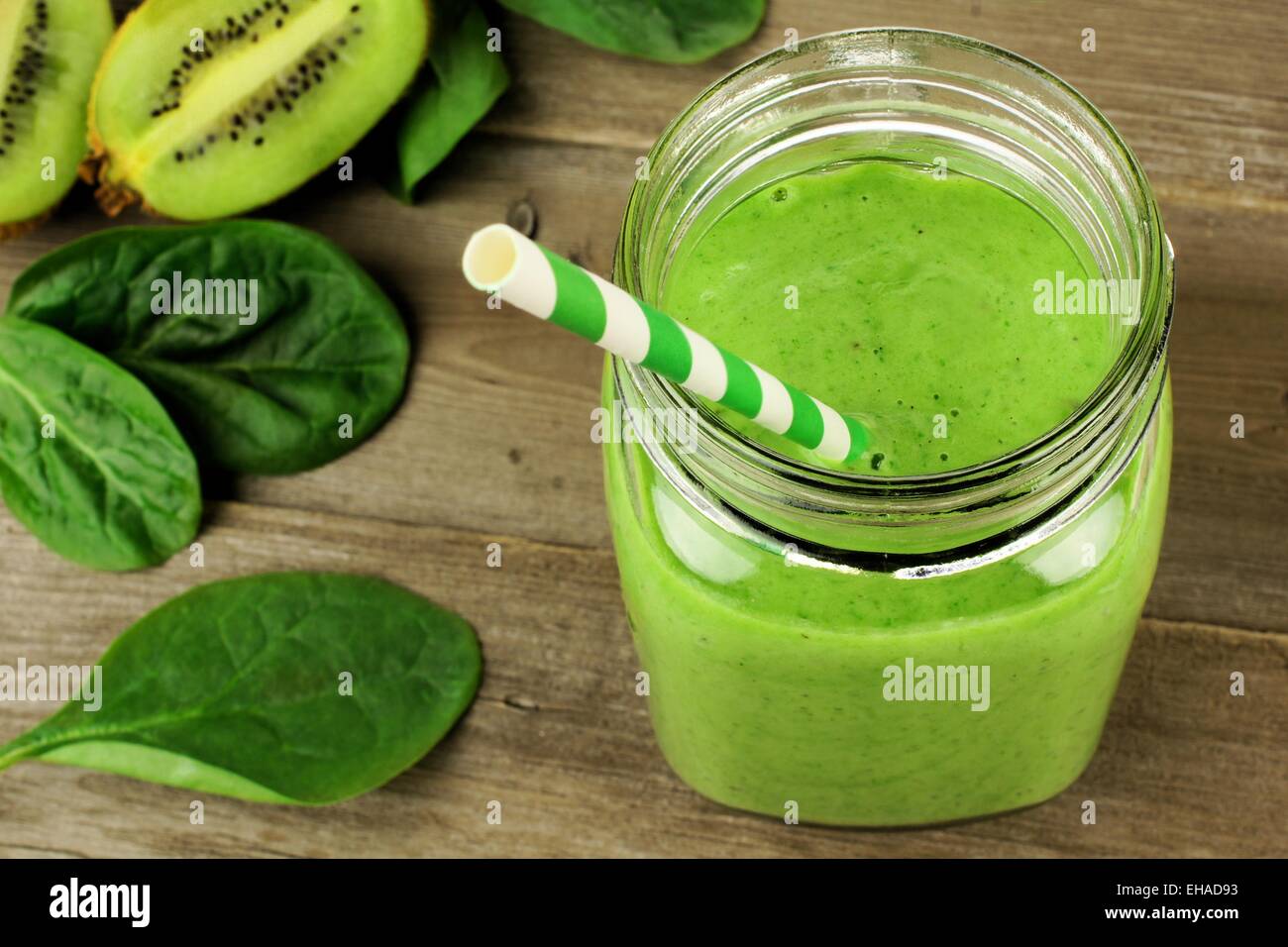 Healthy green smoothie with spinach and kiwi in a jar mug on wood, downward view Stock Photo