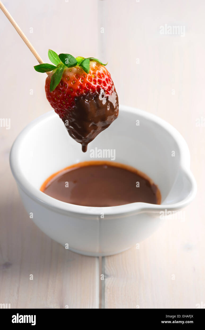 Strawberry in a skewer dipped in melted chocolate Stock Photo Alamy