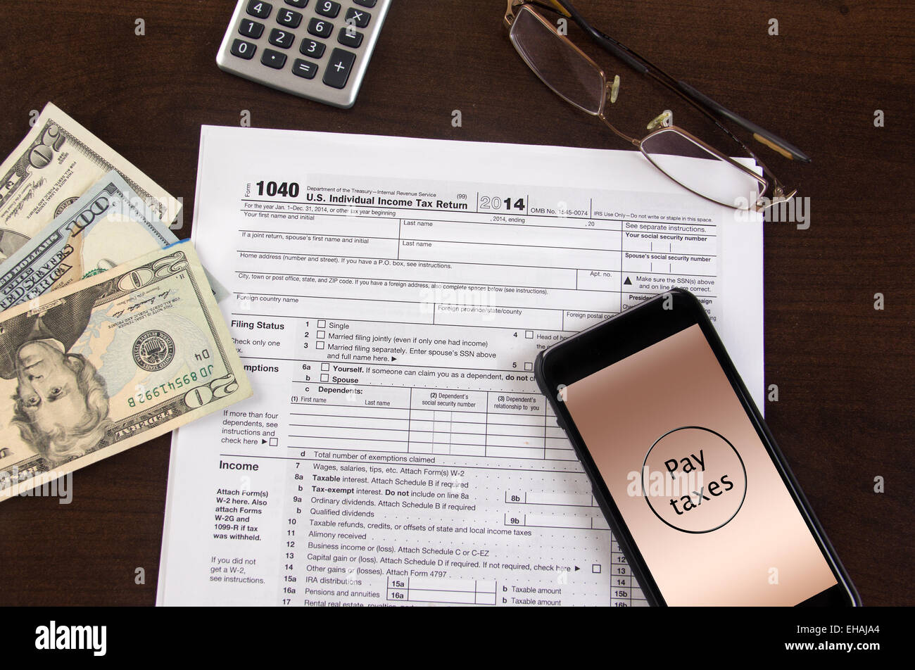 Mobile tax filing 1040 forms with cell phone and calculator Stock