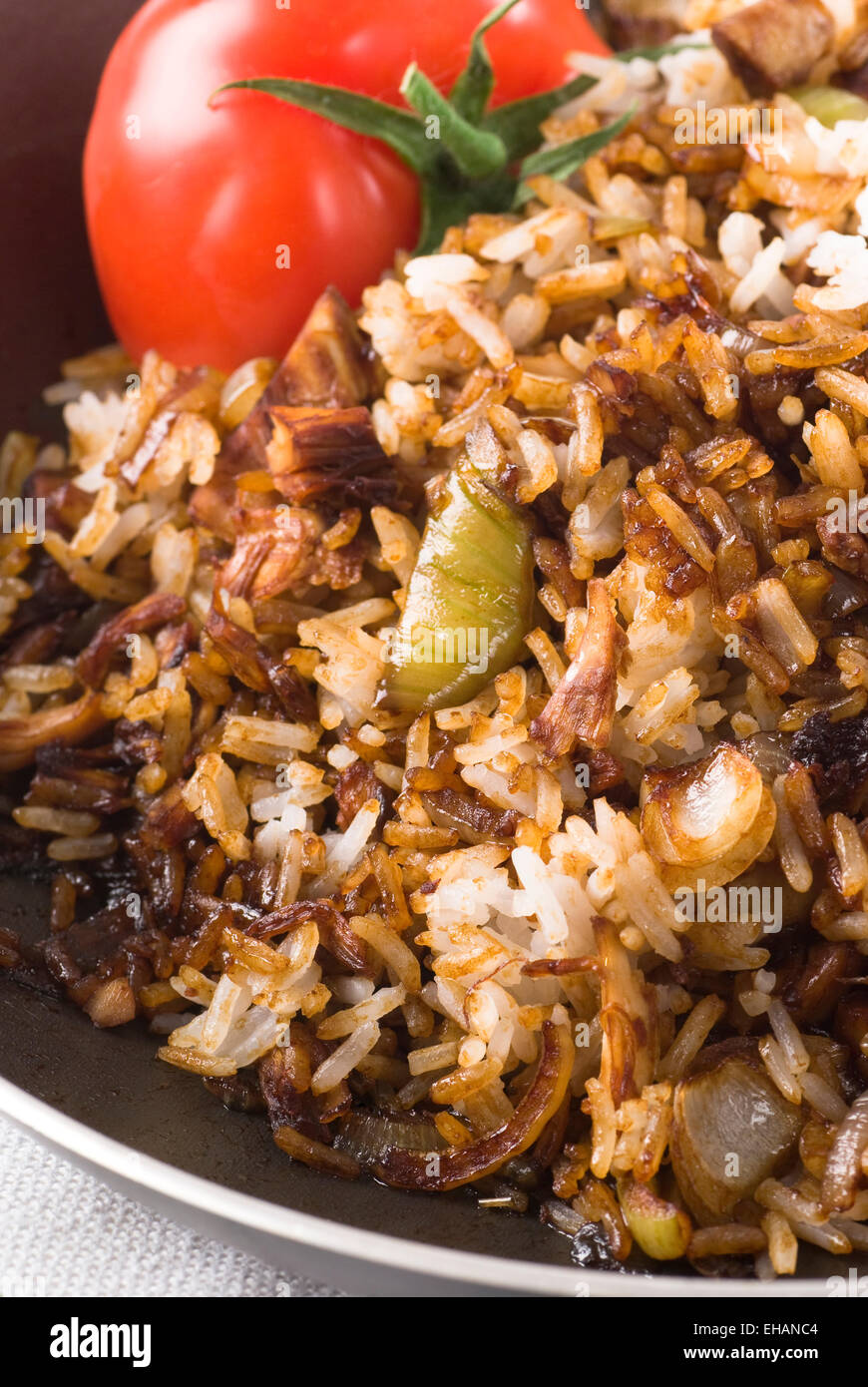 Fried rice with chicken, onion and soy sauce in a pan. Stock Photo