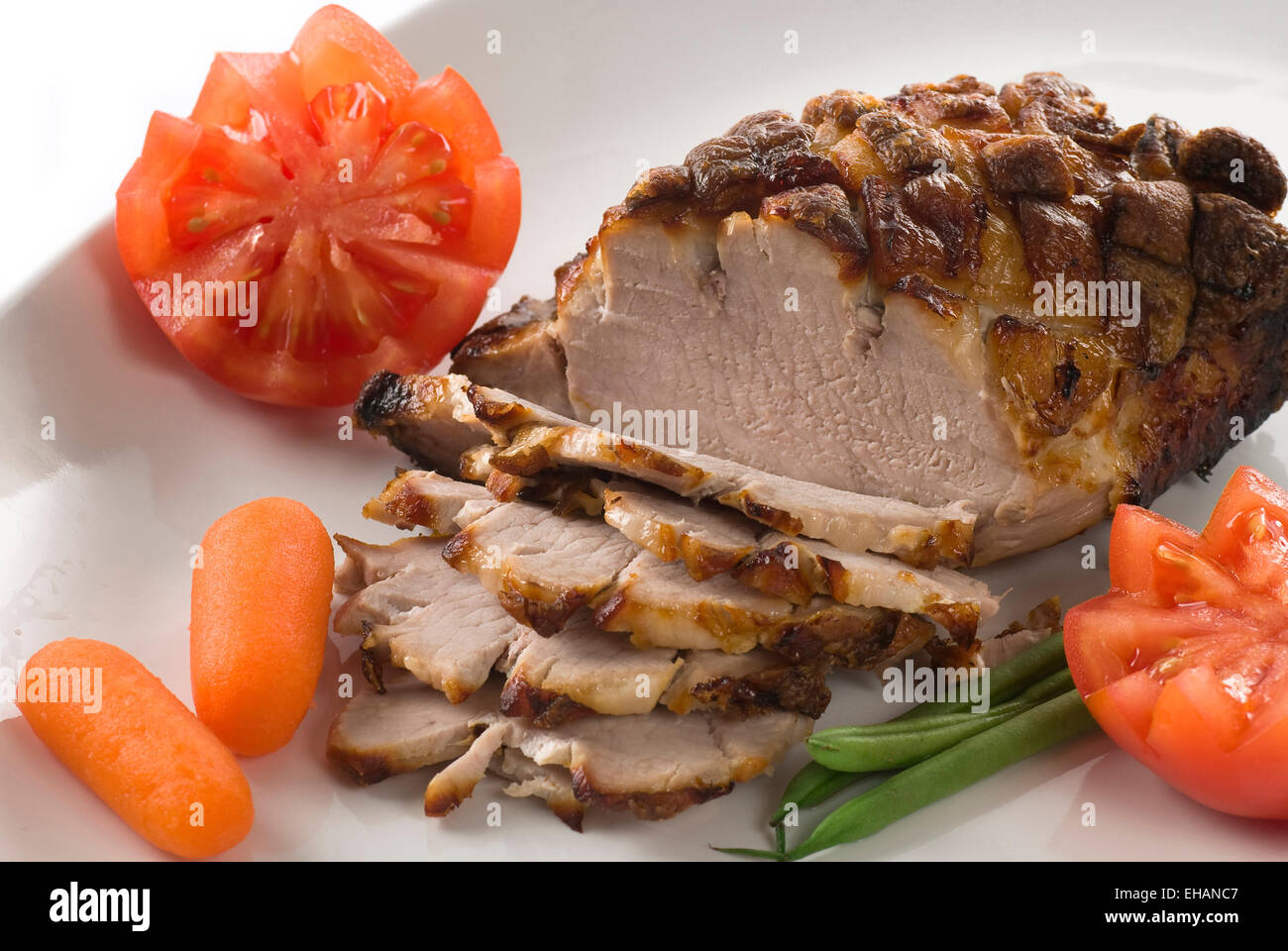 Roasted pork with green beans, tomato and carrot. Stock Photo