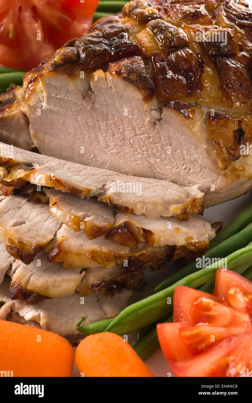 Roasted pork with green beans, tomato and carrot. Stock Photo
