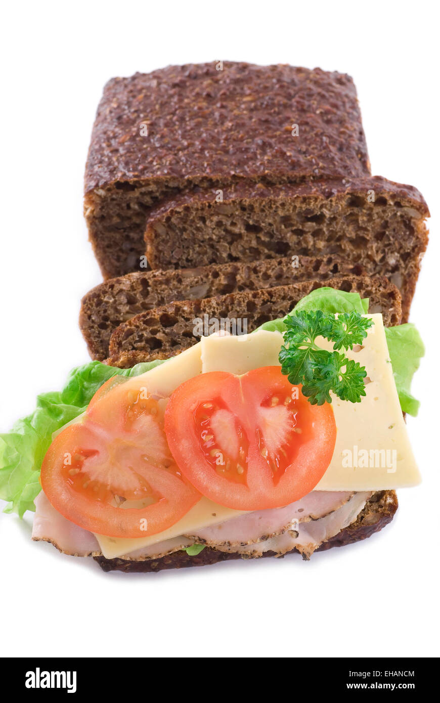 Rye bread with cheese and ham, tomato lettuce and parsley. Stock Photo