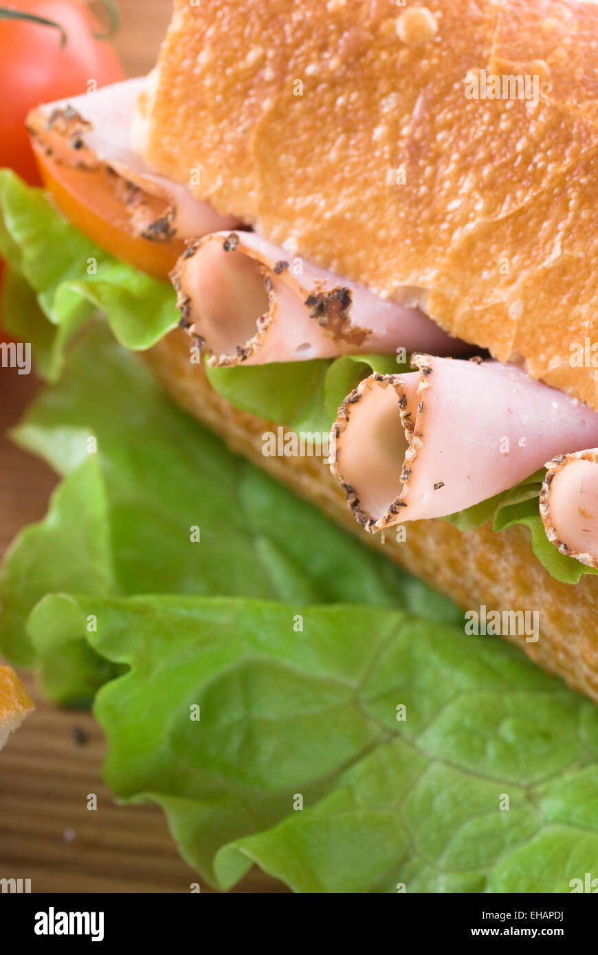 Baguette with pastrami/ham, lettuce and tomato. Stock Photo