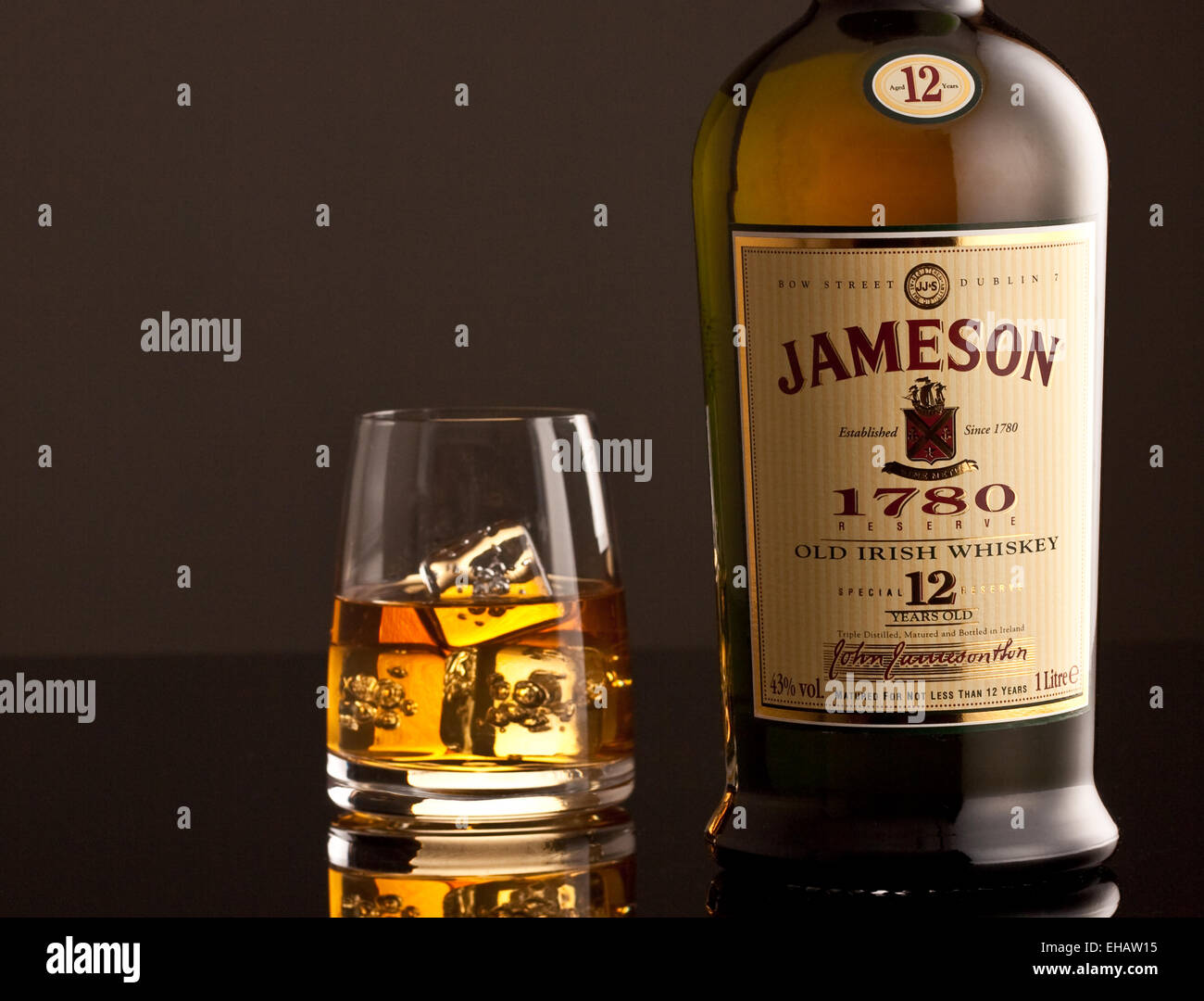 Jameson Whiskey bottle and glass with ice cubes Stock Photo