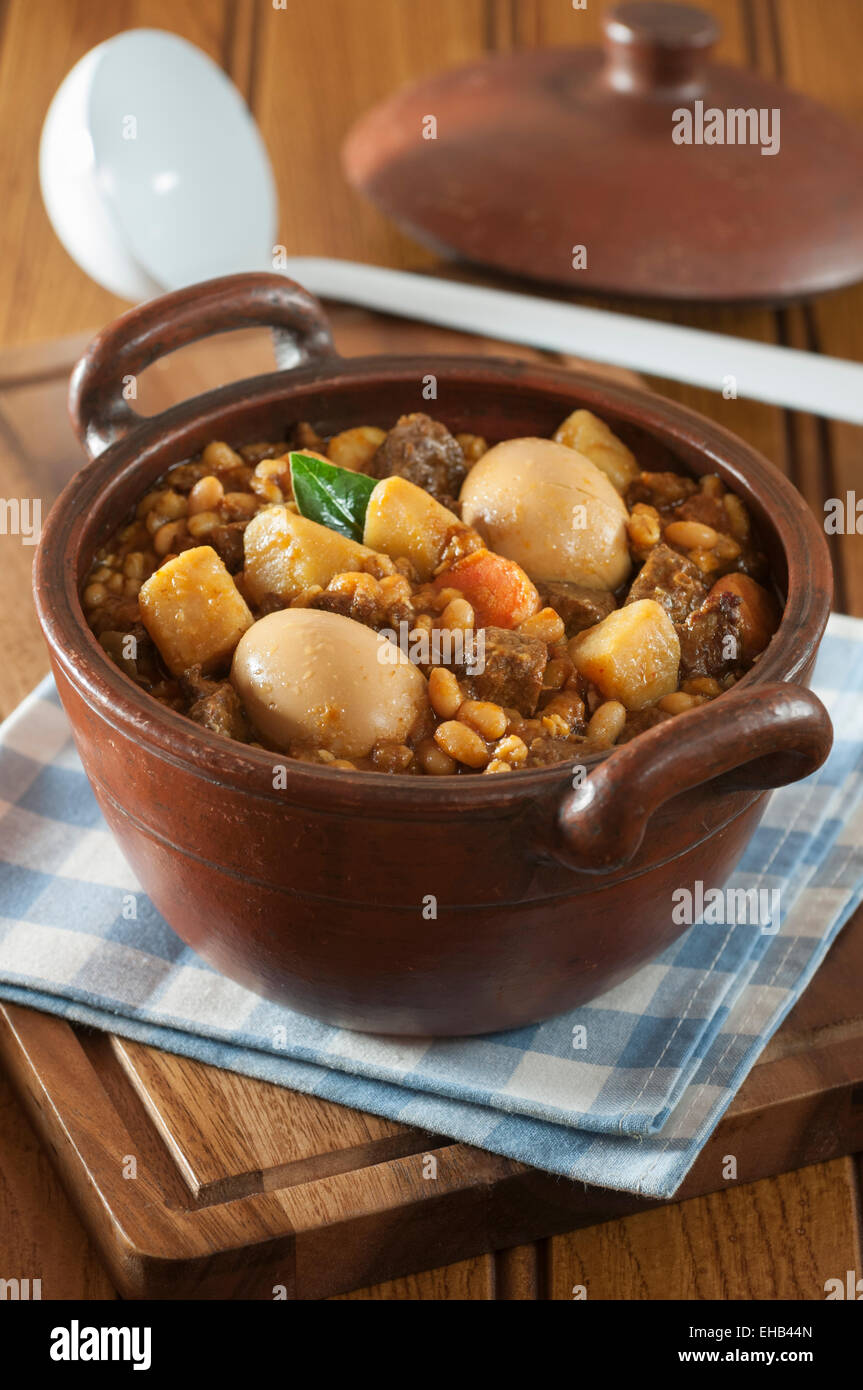 Hot plate for the Sabbath, a pot of spicy meat cooked with potatoes,  barleys, wheat and eggs. Pot of cholent Hamin in hebrew, challah-special  bread in Jewish cuisine. Traditional food Jewish Shabbat