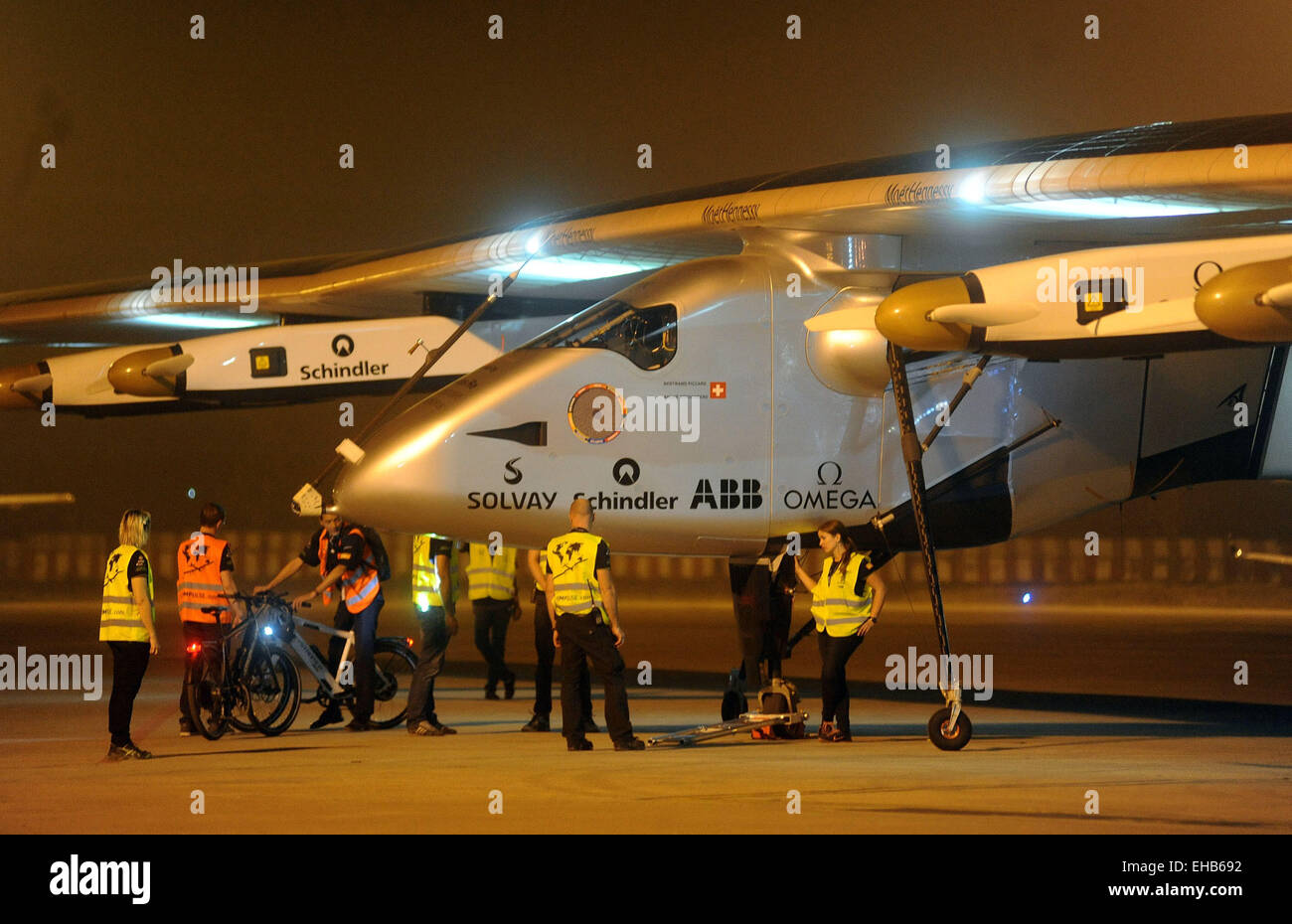 Ahmadabad. 11th Mar, 2015. Crew members gather to push the Solar Impulse 2 (Si2) towards a hangar after it landed at an airport in the western Indian city of Ahmadabad, March 11, 2015. A solar powered aircraft, Si2 which is on a global flight, landed in the western Indian city of Ahmadabad before Tuesday night, said TV channel NDTV. © Stringer/Xinhua/Alamy Live News Stock Photo