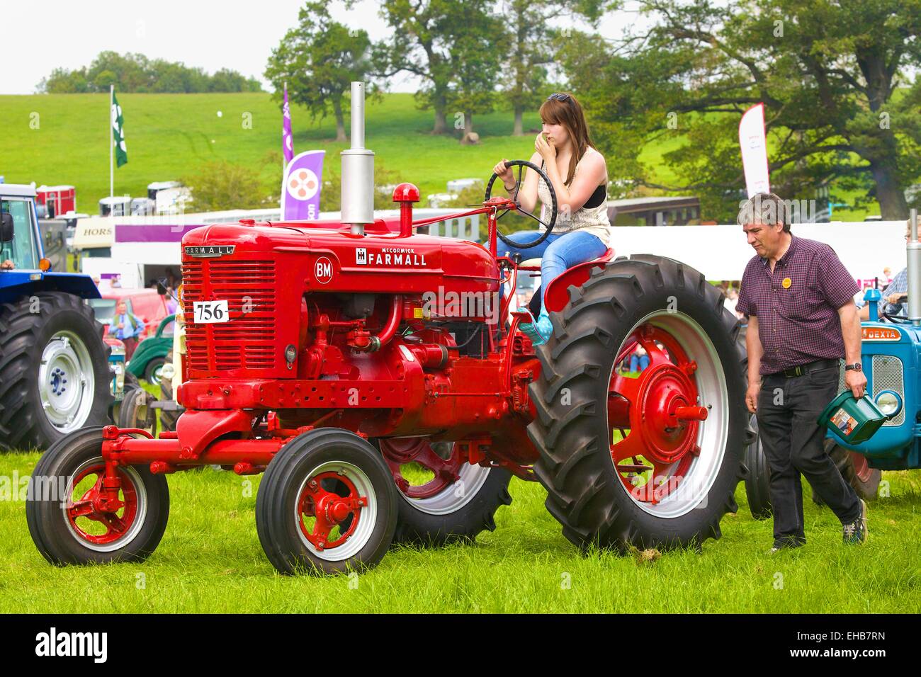 Young woman on McCormick Farmall BM classic tractor. Skelton Show Cumbria, England, UK. Stock Photo