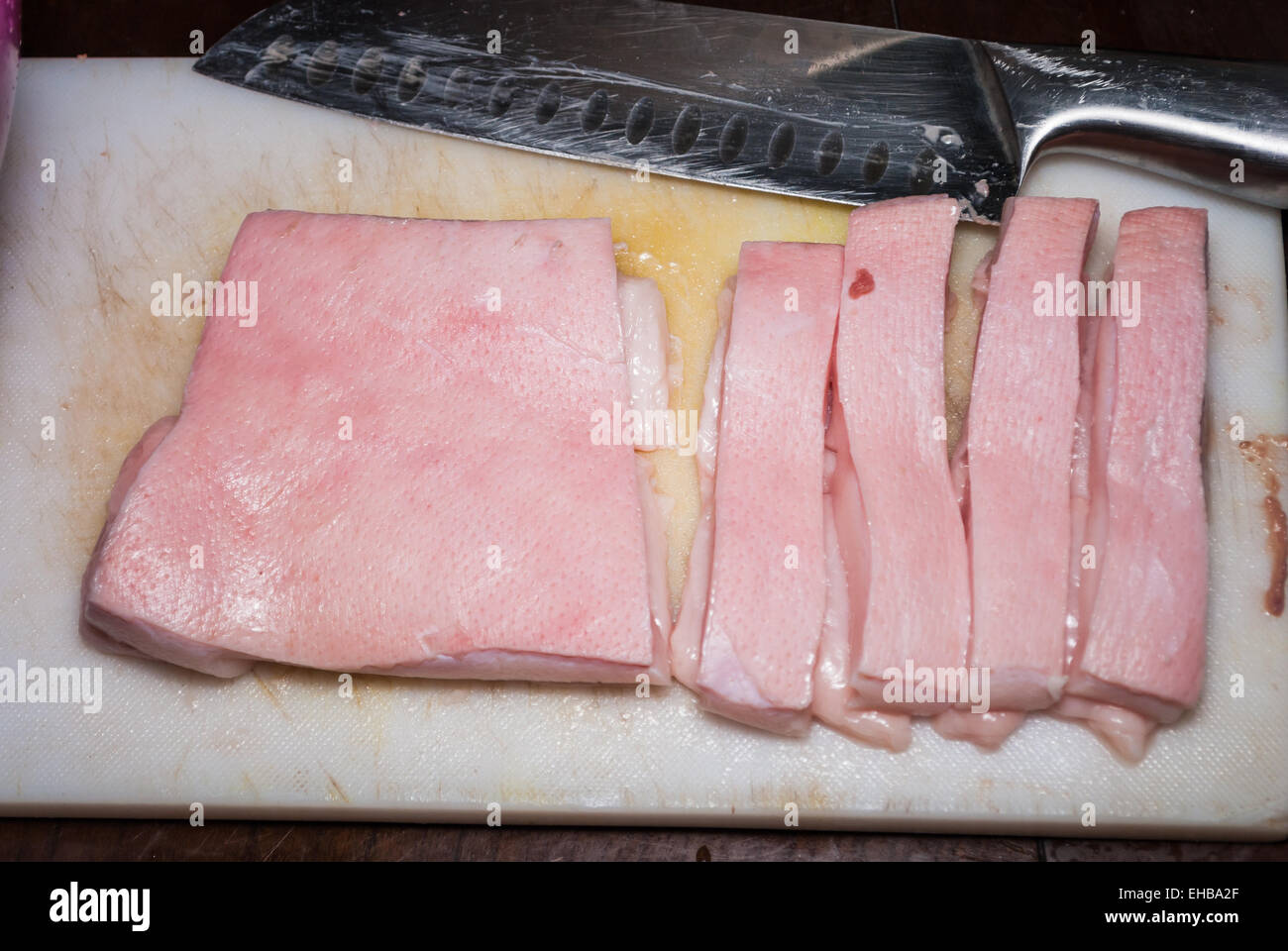Cut Raw Pork Skin on Chopping Board. Stock Photo
