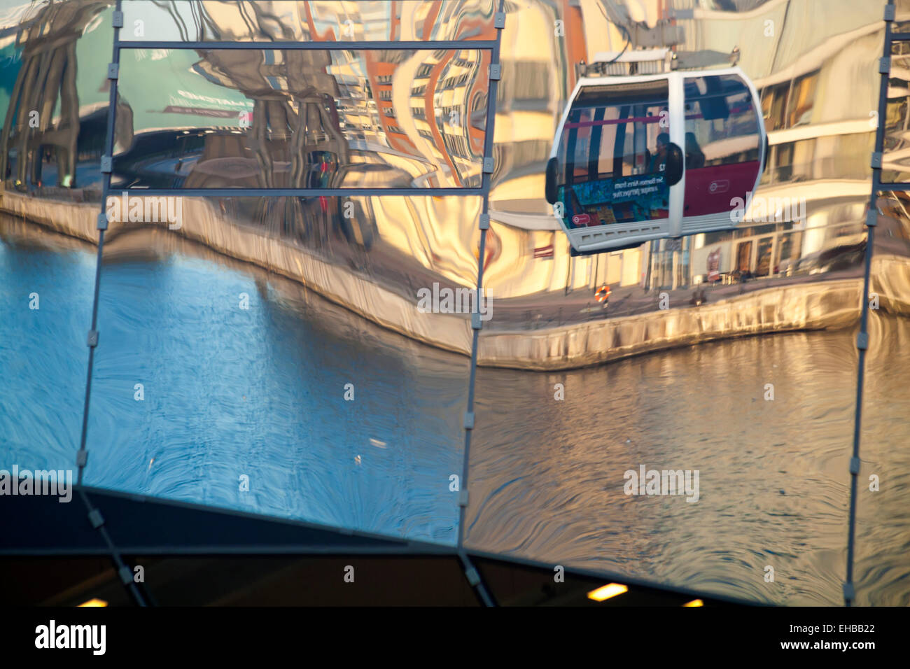 reflections of Emirates Air Line Cable Car ride between Greenwich Peninsula and the Royal Docks in buildings opposite, London Stock Photo