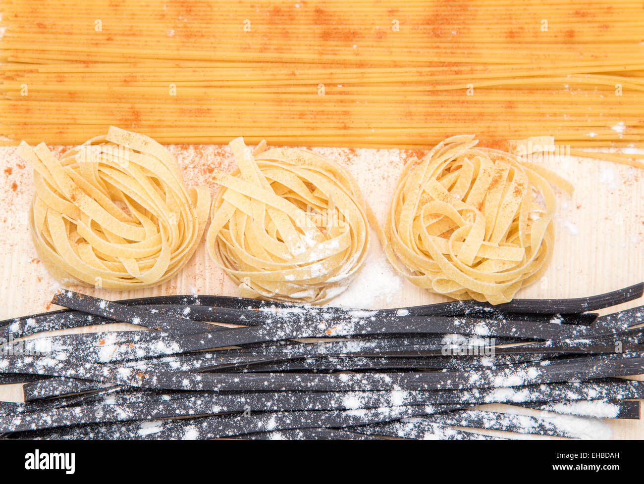 still life: spaghetti, black pasta, flour on the wooden table Stock Photo