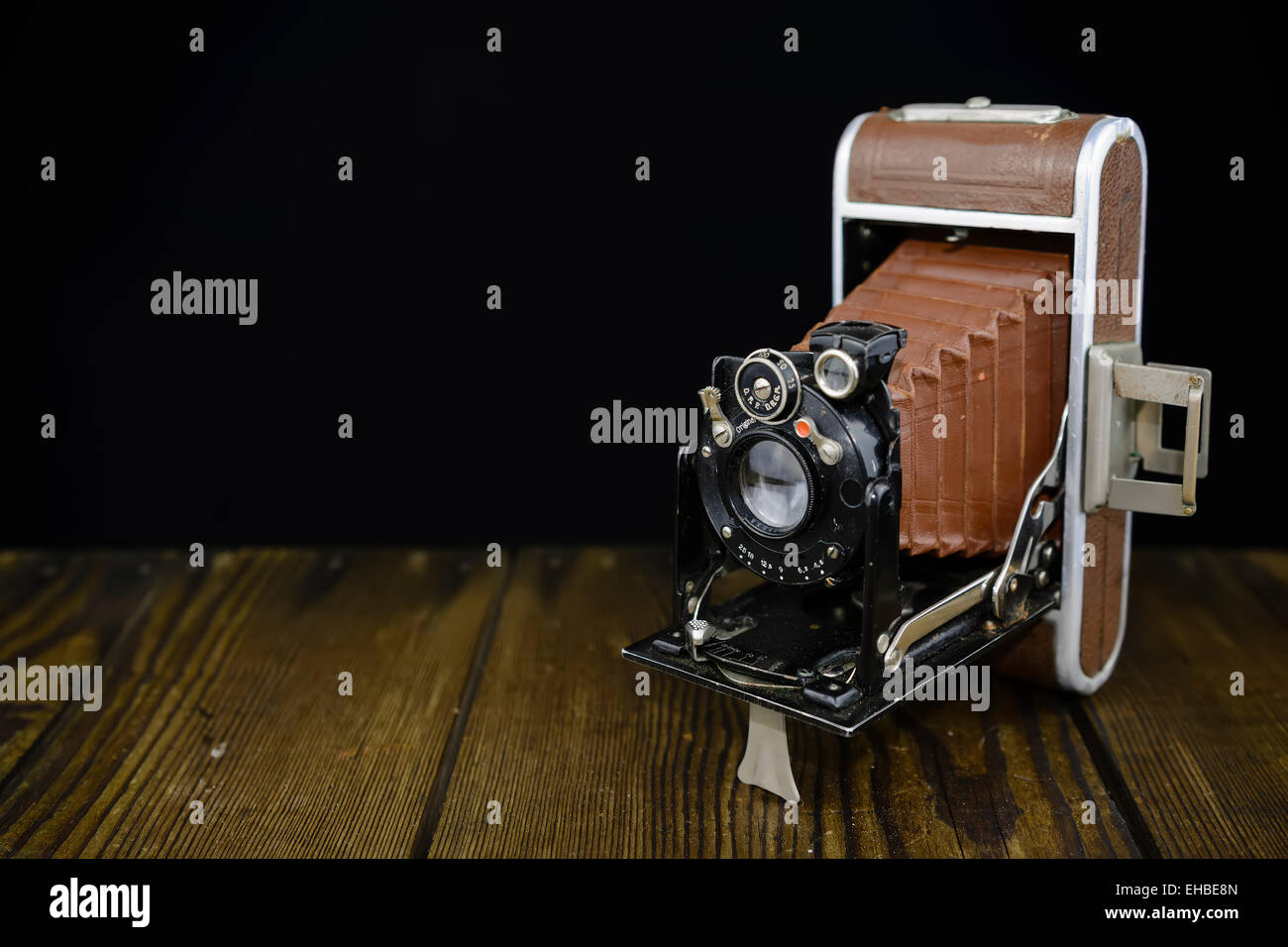 German made vintage camera on wooden board and black background Stock Photo
