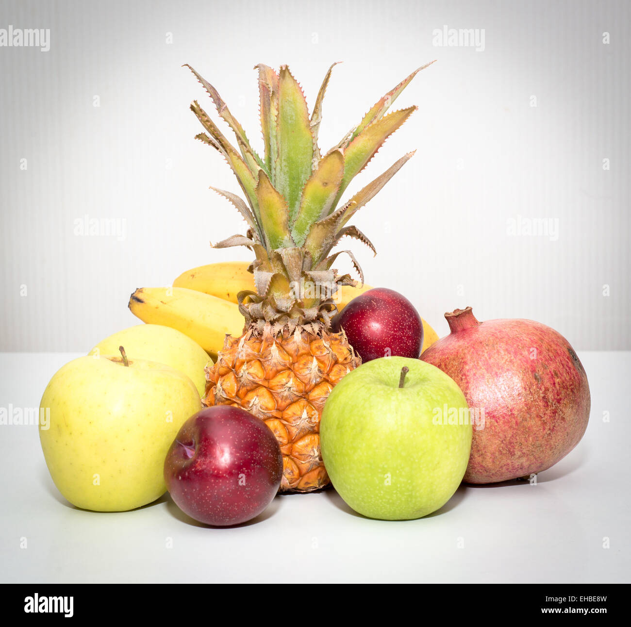 still life of fruit pineapple, apples, bananas, plums, pomegranate