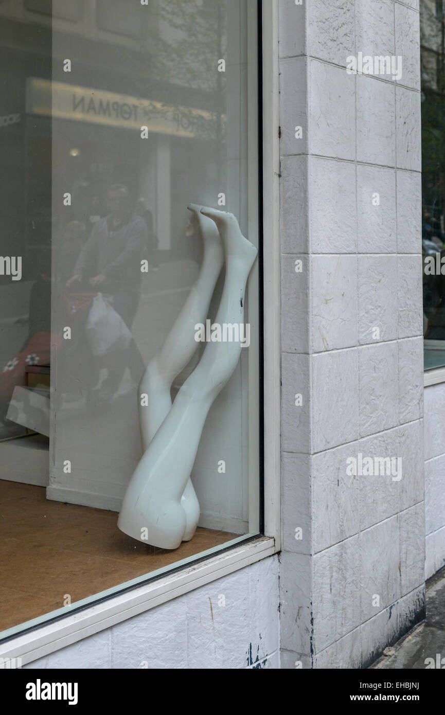 Upside down inverted legs of a dummy manikin mannequin in an empty shop during the recession credit crunch economic downturn. Stock Photo