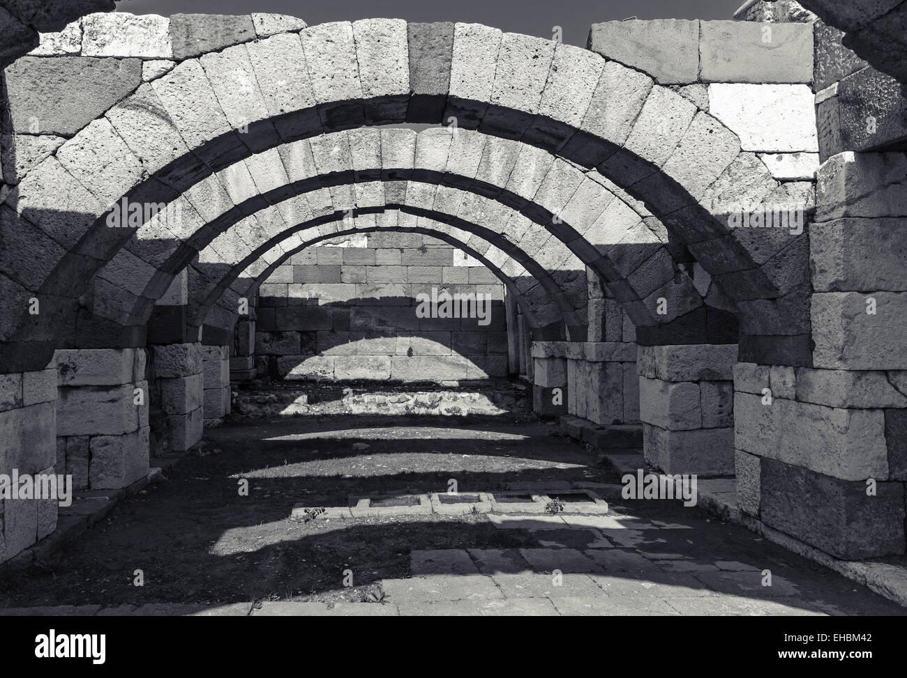 Interior of empty corridor with arcs. Ruins of Ancient city Smyrna. Izmir, Turkey. Black and white photo Stock Photo