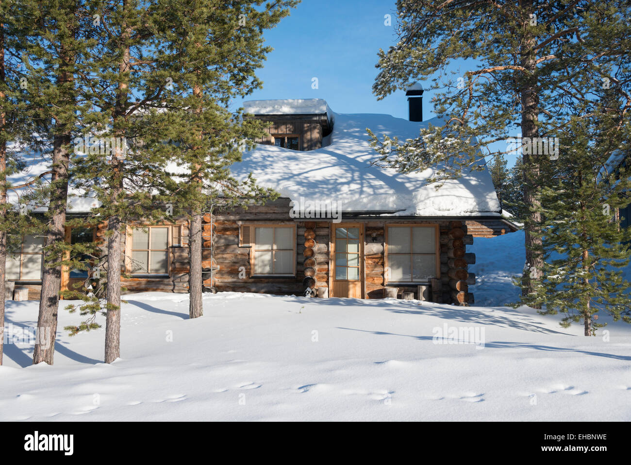 A log cabin in Levi Lapland Finland with snow and winter sunshine. Used as winter holiday accommodation Stock - Alamy