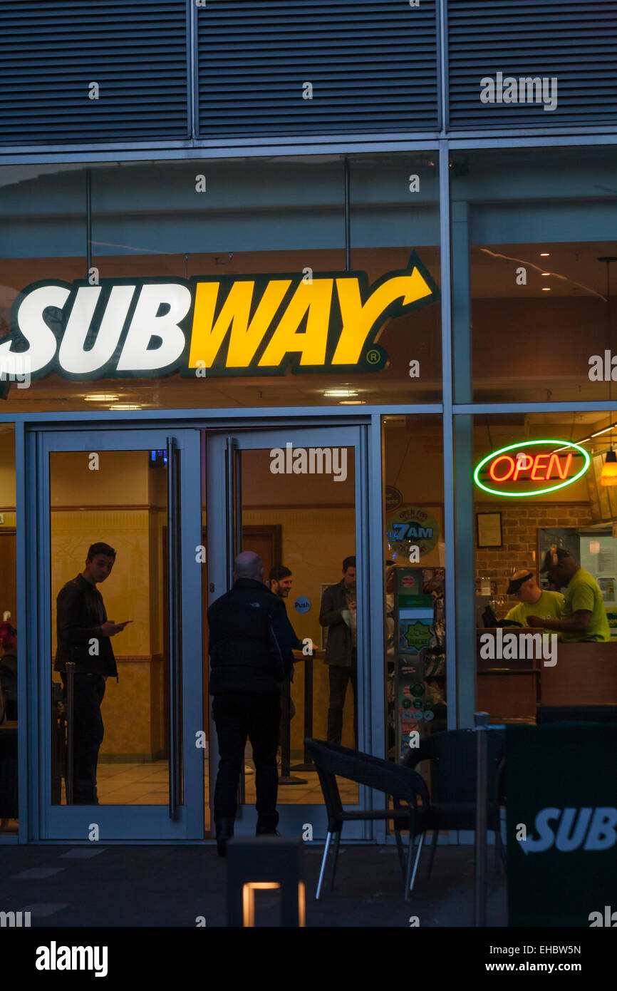 Customers in Subway fast food store at dusk at Greenwich Peninsula, London UK in March Stock Photo