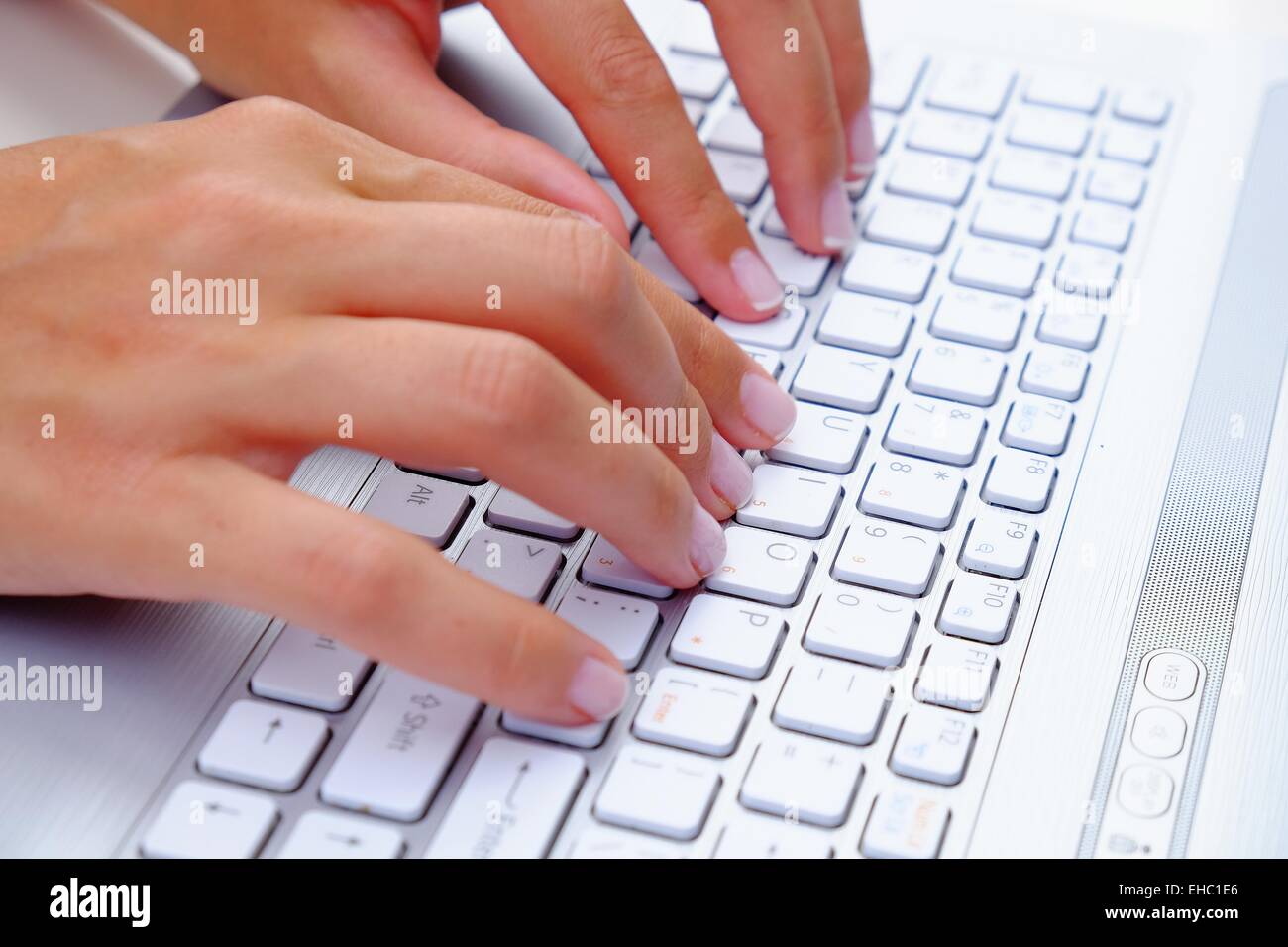 Keyboard Typing.female texting on a white laptop keyboard Stock Photo