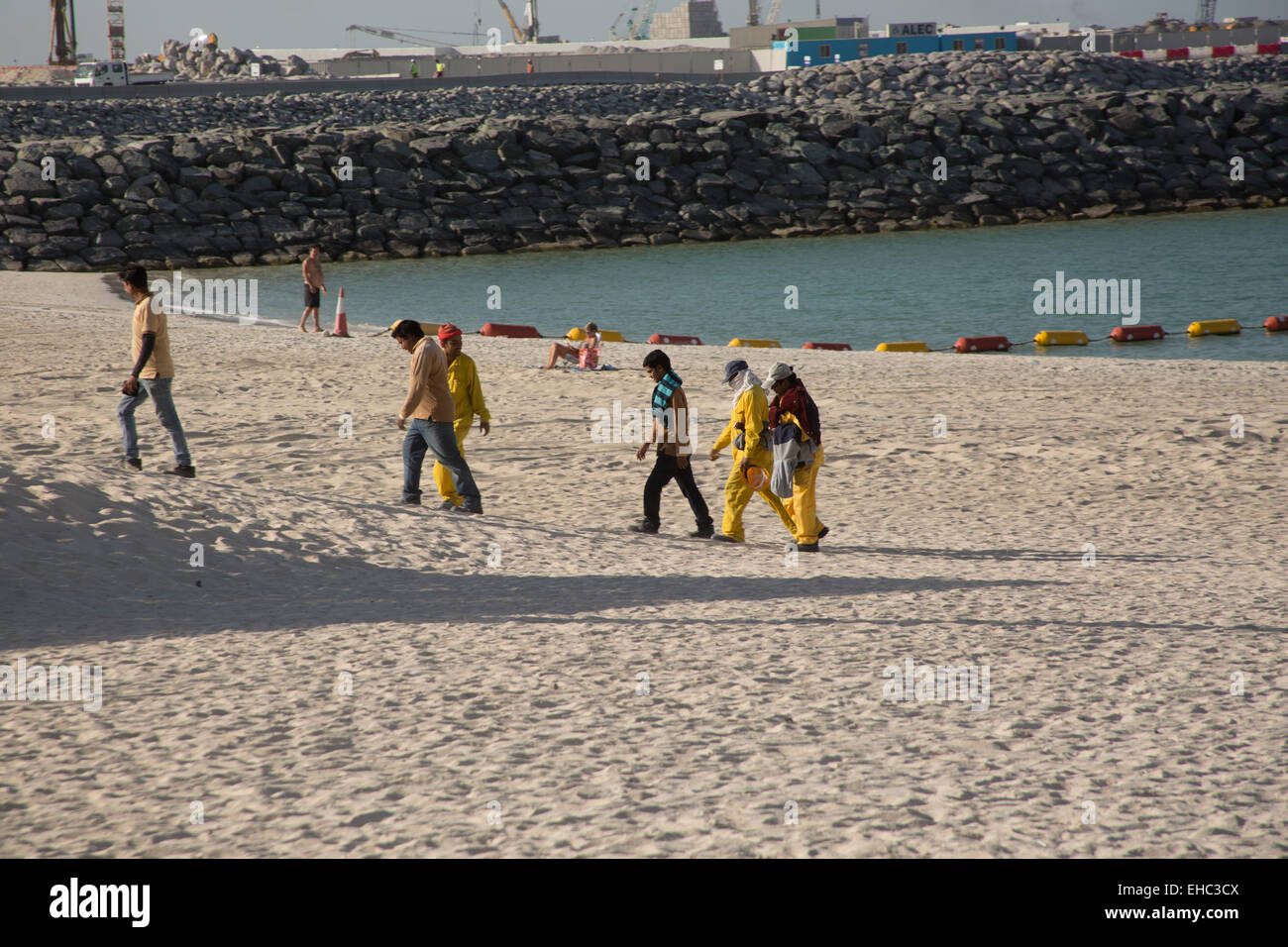 Workmen on Jumeirah beach, Dubai UAE Stock Photo