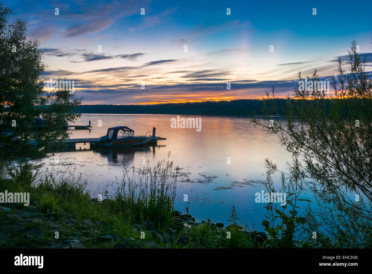 Beautiful sunset on the river Volga. Red-blue sky reflected in the mirrored surface of the water. Stock Photo