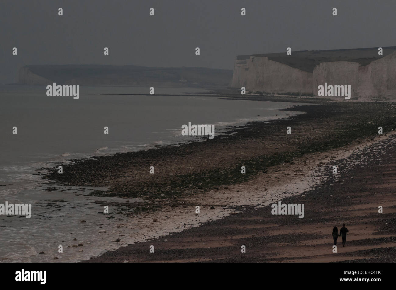 Birling Gap, East Sussex, UK.11 March 2015. Weather: Couple take an evening walk as cloud blocks out the sun and mist rolls in from the sea Stock Photo