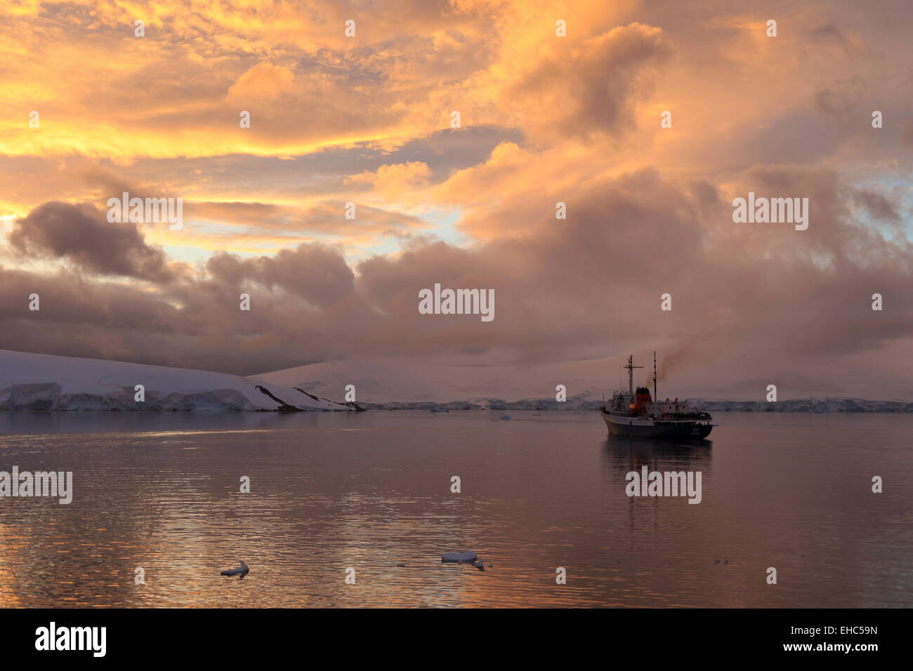 Antarctica landscape sky image of sunset at Port Lockroy. Tourist cruise ship, expedition ship the Ushuaia. Stock Photo