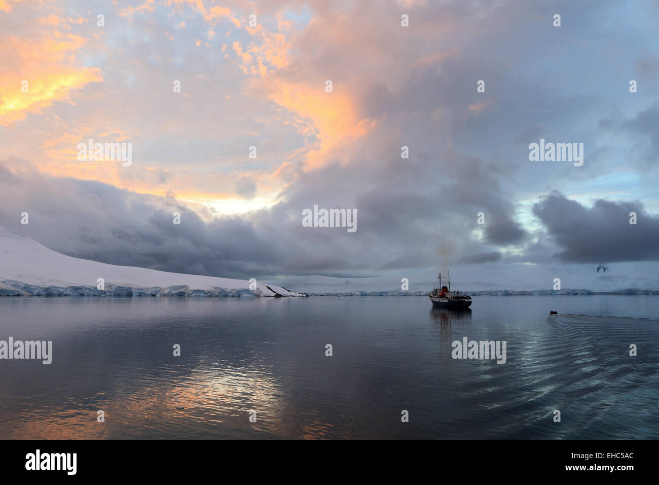 Antarctica landscape image of sunset at Port Lockroy. Tourist cruise ship, expedition ship the Ushuaia. Stock Photo