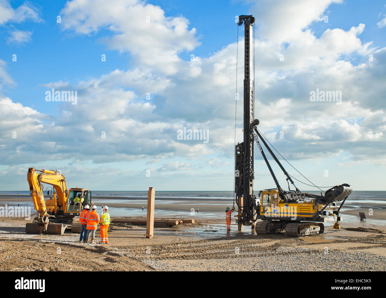 Pile driver at work, driving timber groynes into Camber Sands. Stock Photo