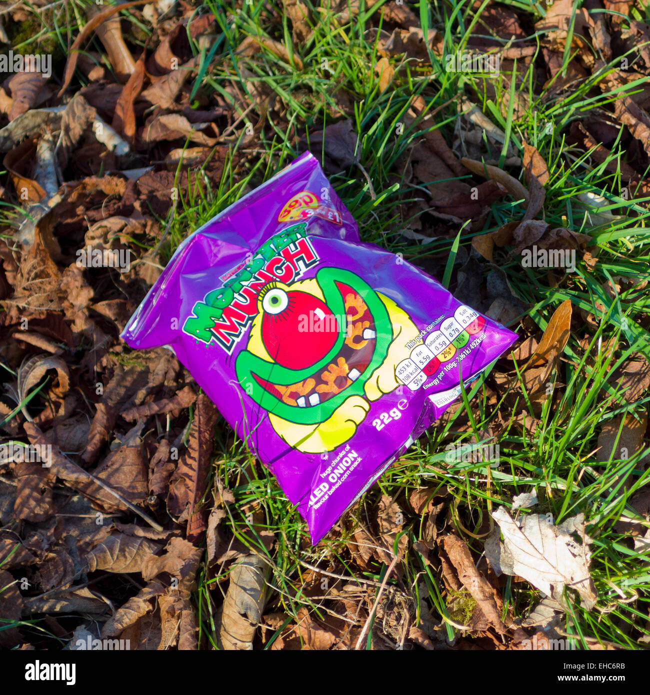 Empty Monster Munch Crisp Packet Littering a Lawn, UK Stock Photo