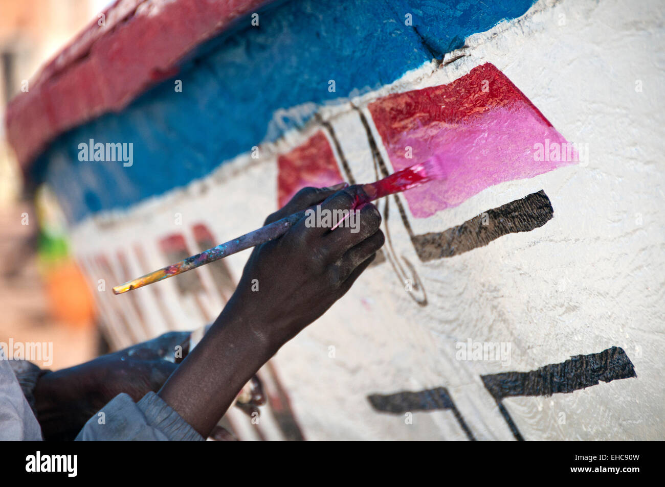 Close up of Gambian Fisherman's Hands Repainting His Boat, Tanji Fishing Village, The Gambia, West Africa Stock Photo
