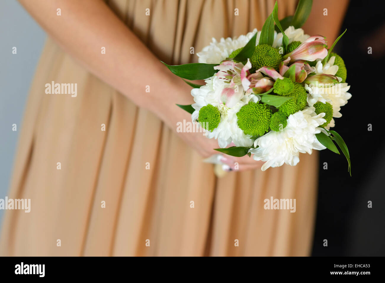 Bridesmaid holding in her hands a bouquet of flowers Stock Photo