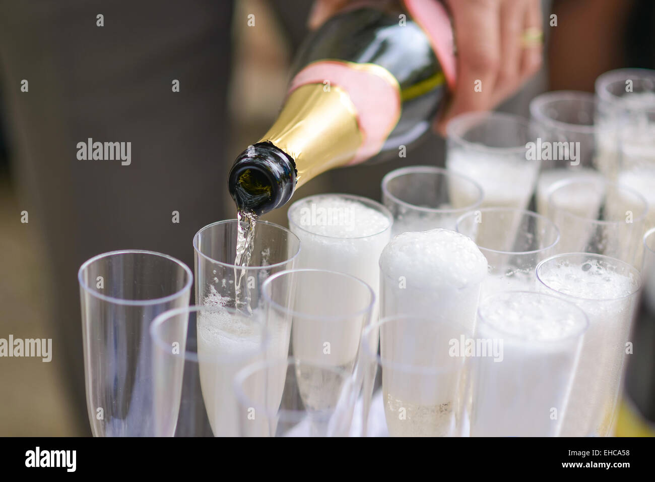 Someone poured a bottle champagne in glasses Stock Photo