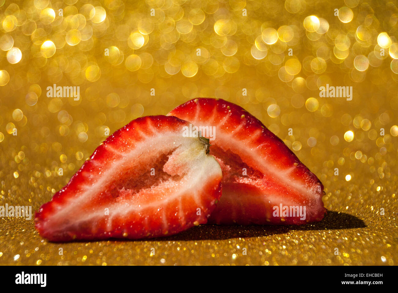 Open strawberry on gold glittery background full of bokeh Stock Photo ...