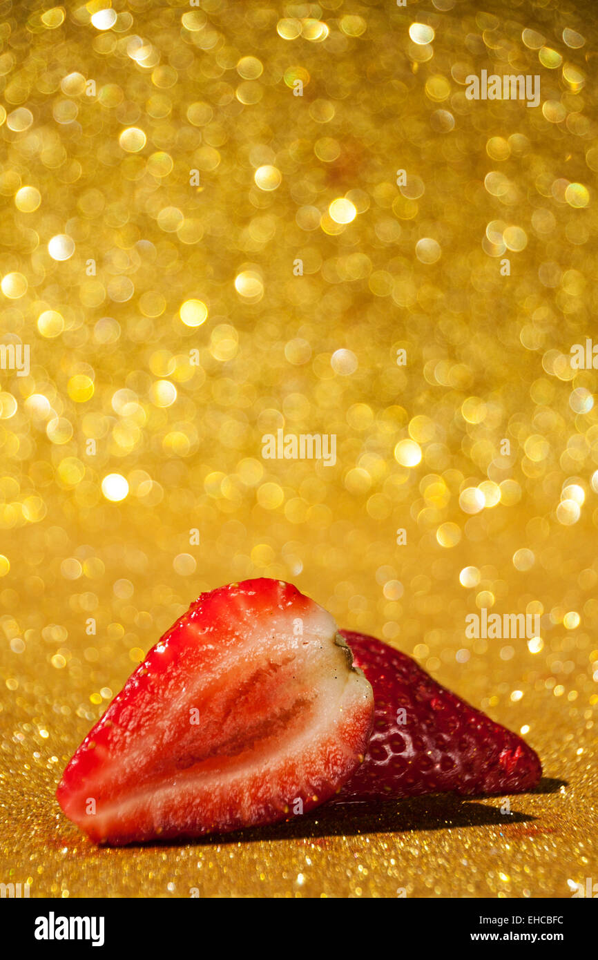 Open strawberry on gold glittery background full of bokeh Stock Photo ...