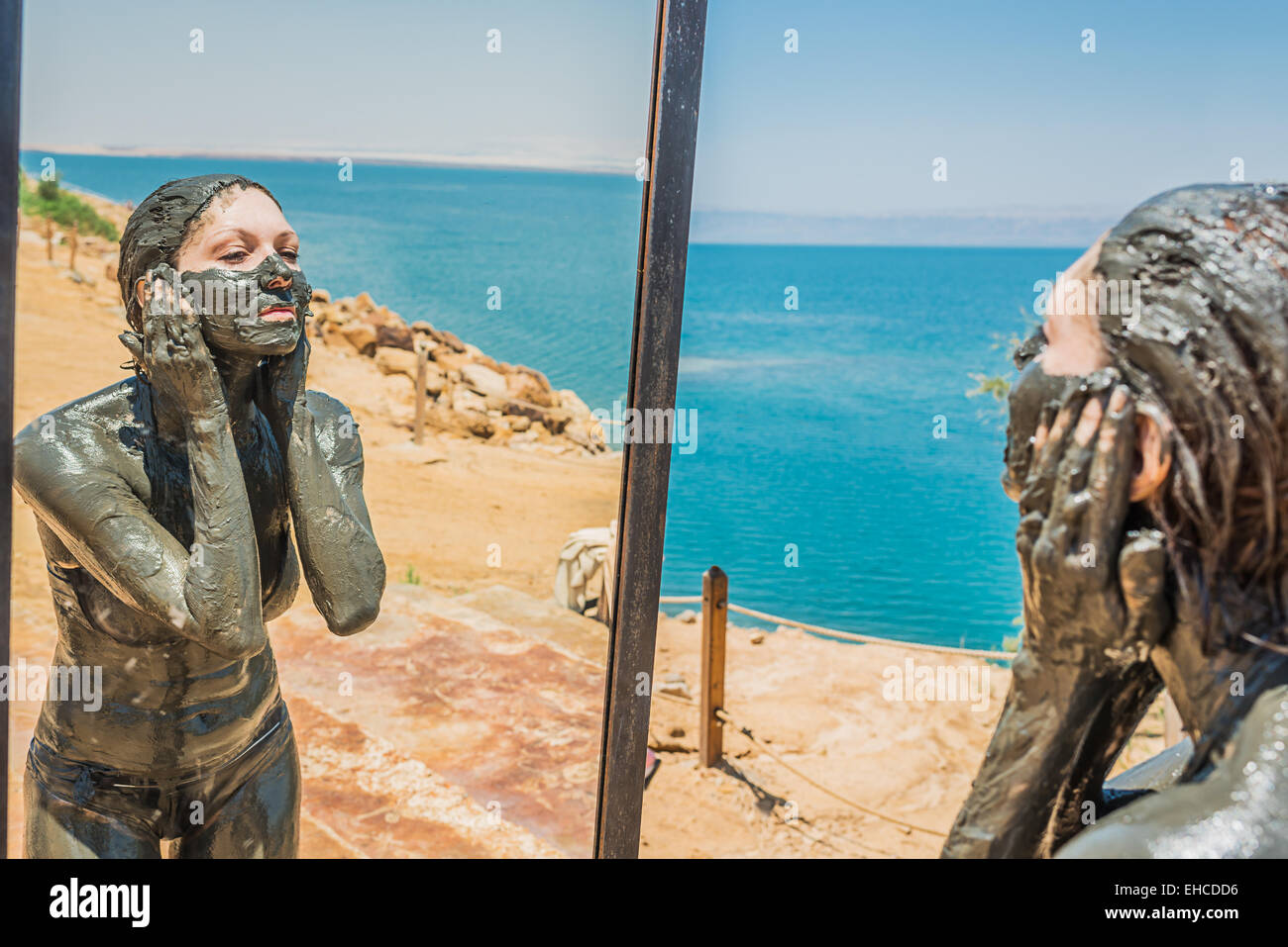 one woman applying Dead Sea mud body care treatment in Jordan Stock