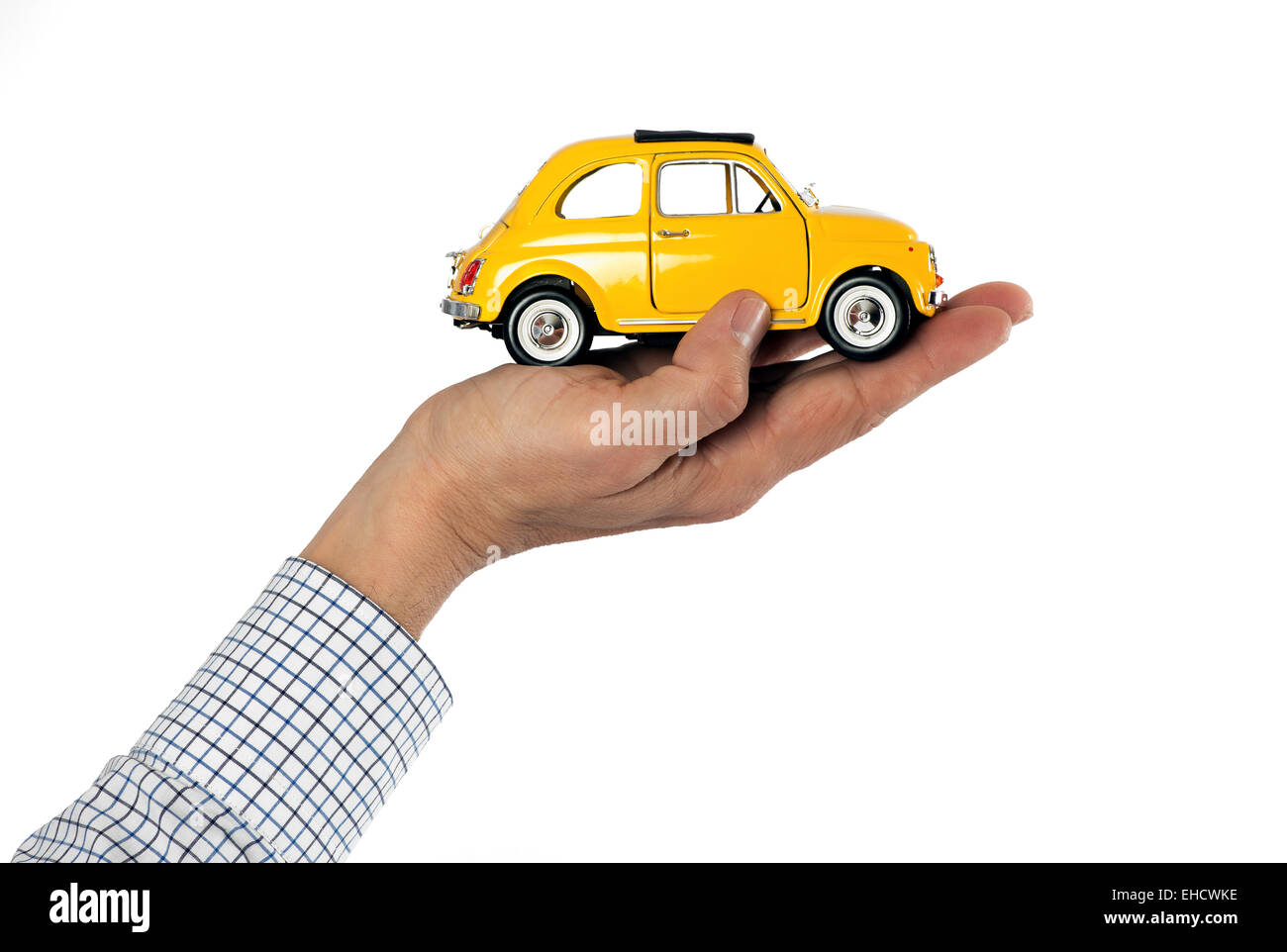 Adult Male Hand with Visible Striped Shirt Sleeve Holding Yellow Toy Car Against White Background, Car Care Themed Image Stock Photo