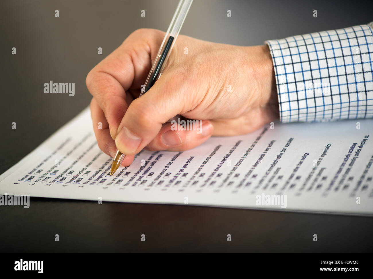 Hand of a man completing a questionnaire Stock Photo