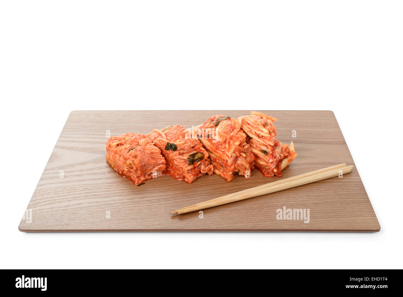 cutted Gimchi with chopsticks on a wooden plate Stock Photo