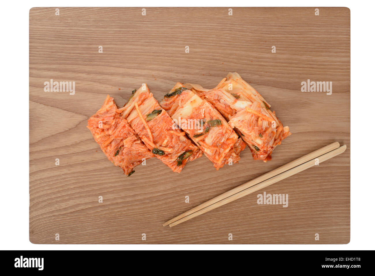cutted Gimchi with chopsticks on a wooden plate Stock Photo