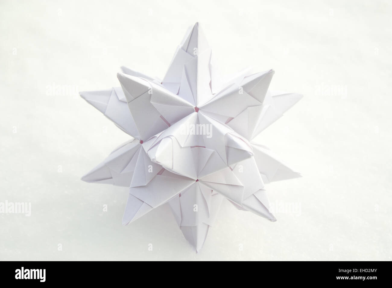 White paper star with snow as background. Stock Photo