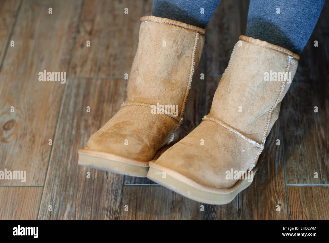 Closeup of brown Ugg boots with wooden background Stock Photo