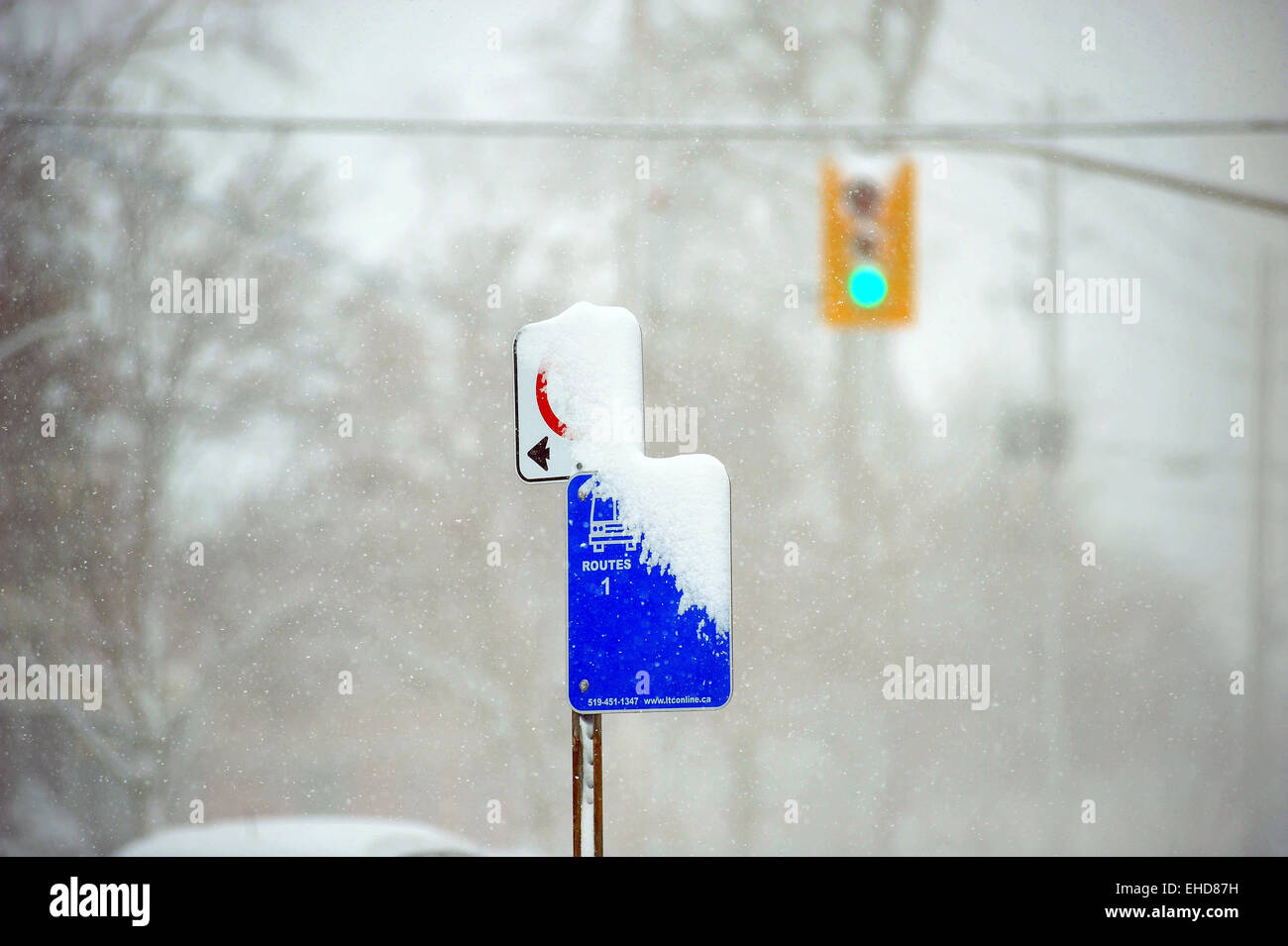 A bus stop sign obscured by snow in Canada. Stock Photo